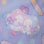 pastel holographic sticker of twin anime boys with teddy bear ears and ribbons.