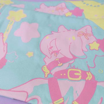 clooseup photo of a pastel blue cotton tshirt with a screen-print illustration of a magical neko boy with handcuffs and gag, and a moon in the background