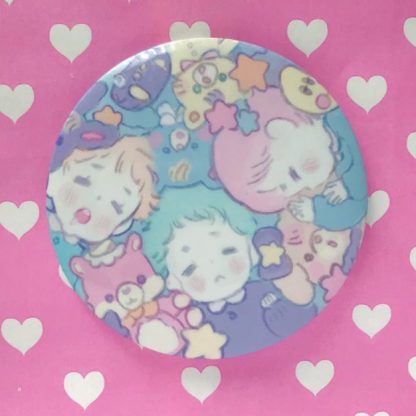 a button in pastel color with sleeping boys with their soft plushies