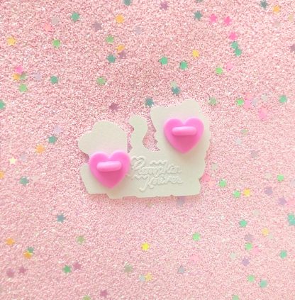 pastel colored enamel pin in a shape of a cute anime nekoboy with words saying "ceo of catboys" with pink heart shape cluth and signed pumpkinknives