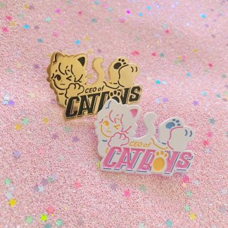Gold and pastel colored enamel pin in a shape of a cute anime neko boy with words saying "ceo of catboys"